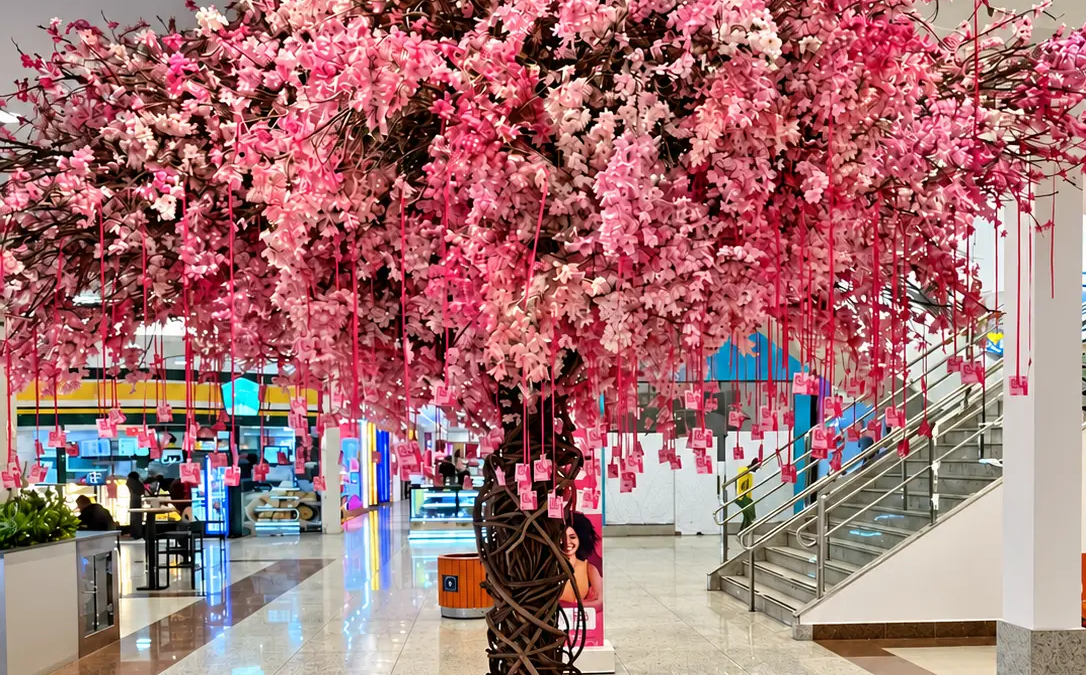 Árvore rosa em shopping de Goiânia convida visitantes a colher mensagens de autocuidado